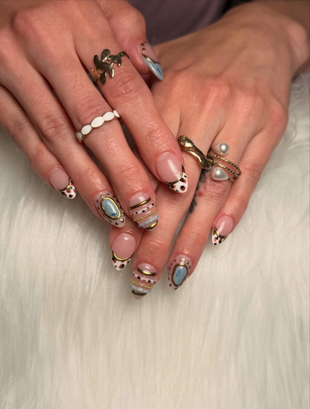 Gold swirl and gemstone nail art with a dalmatian print accent